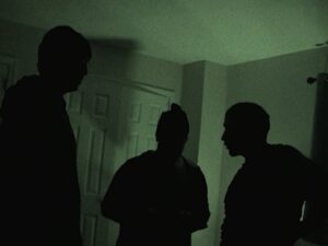 People standing in dark room with green light