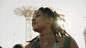 Person looks to left with sun behind hair.
