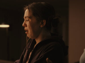 Person looking to left and crying in low light environment