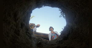 Two people look into a hole.