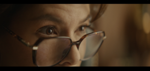 Close up of person looking forward with glasses.