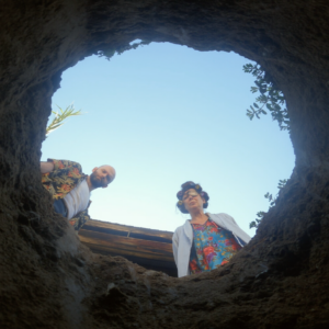 Two people look into a hole.