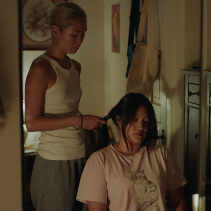 Person does another person's hair that is sitting.