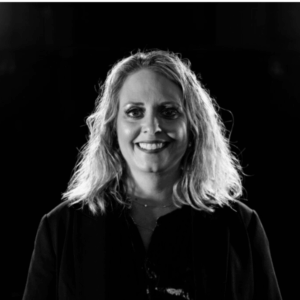 Image in black and white of a person in front of a black background.