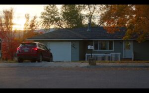 Image of exterior of house and red car in driveway.