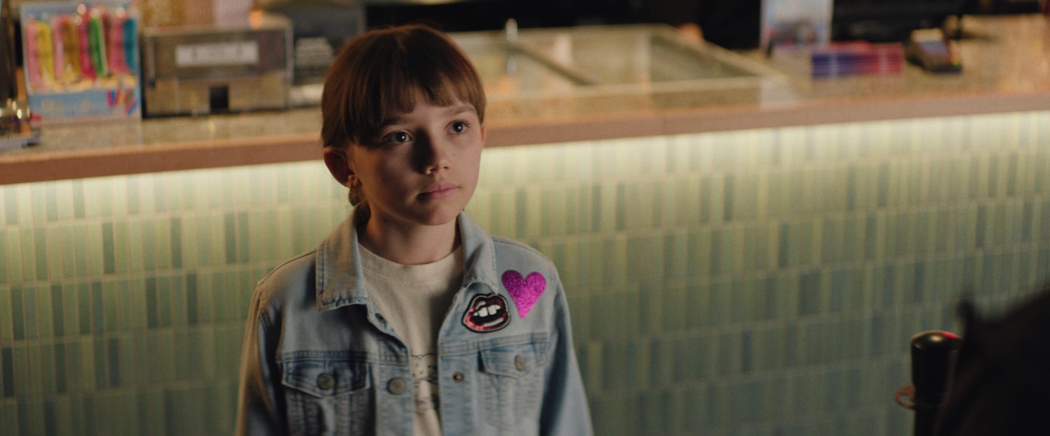 Image of a child looking up in front of a bar.