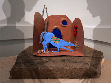 Image of claymation with blue horse and shadows around it.