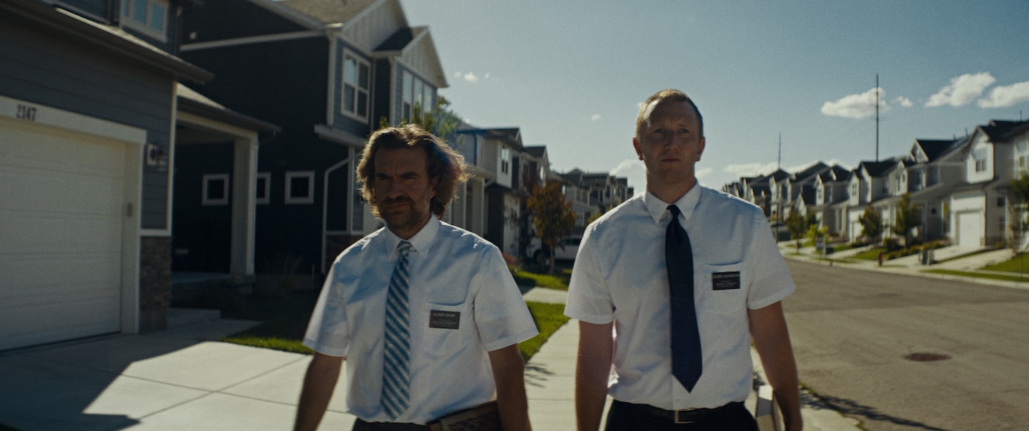 Image of two people in ties walking down a street.