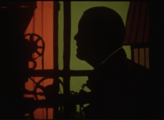 Image of person's head and gears in background of red and green.