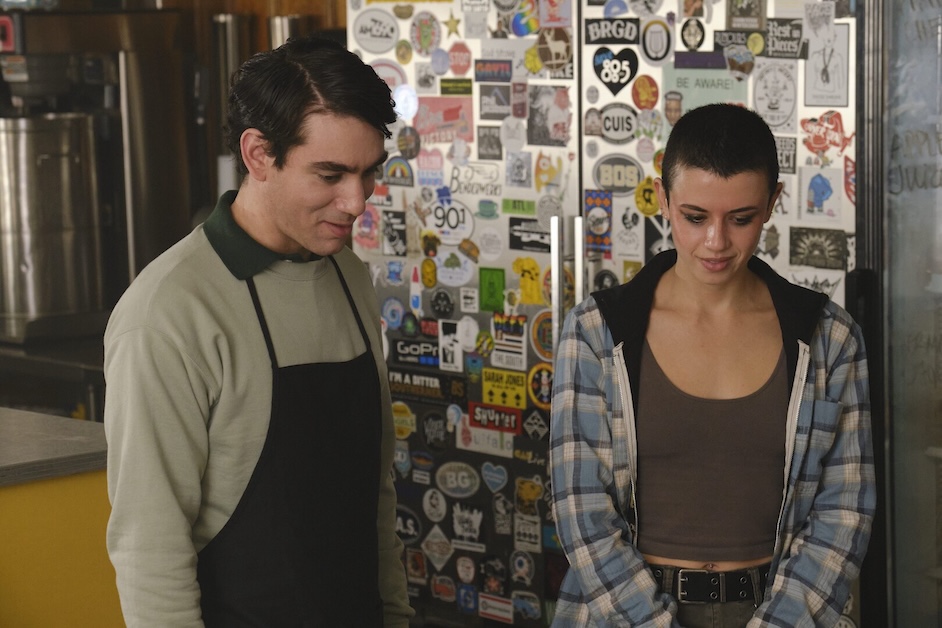 Two people look down standing next to each other.