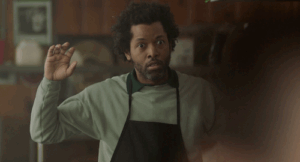 Image of person wearing apron with hands up.