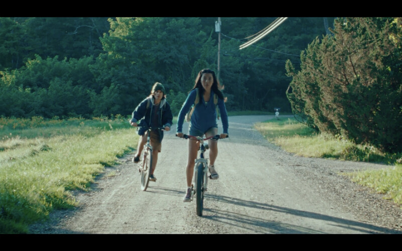 Image of two people biking on gravel road.