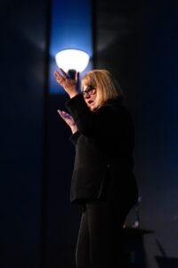 Image of person talking with hands up.