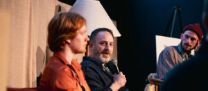 Group of people talking on stage.