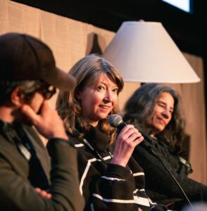 Three people on stage talking.