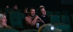 People sitting in theater smile.