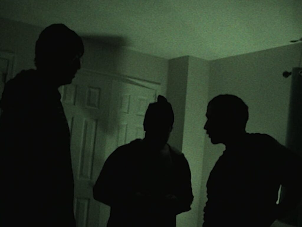 People standing in dark room with green light