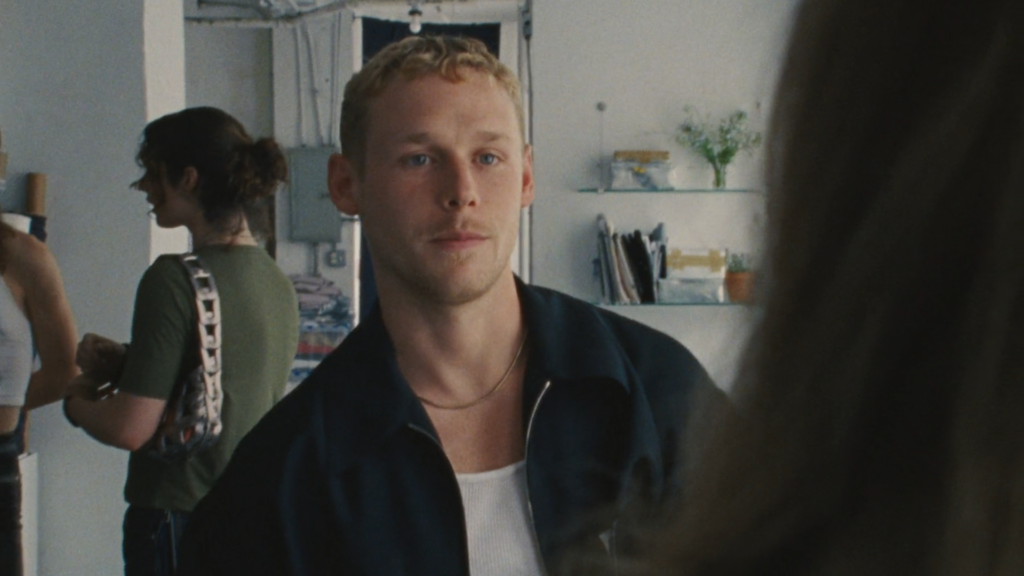 Person looks toward camera in interior setting.
