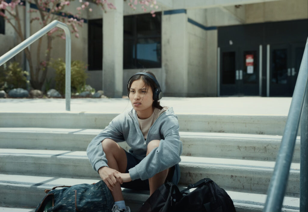 Person sits outside on steps looking off