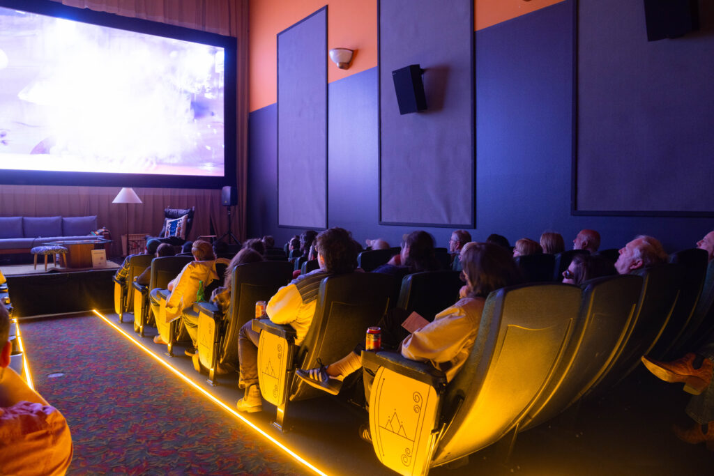 Crowd watching movie in movie theater.