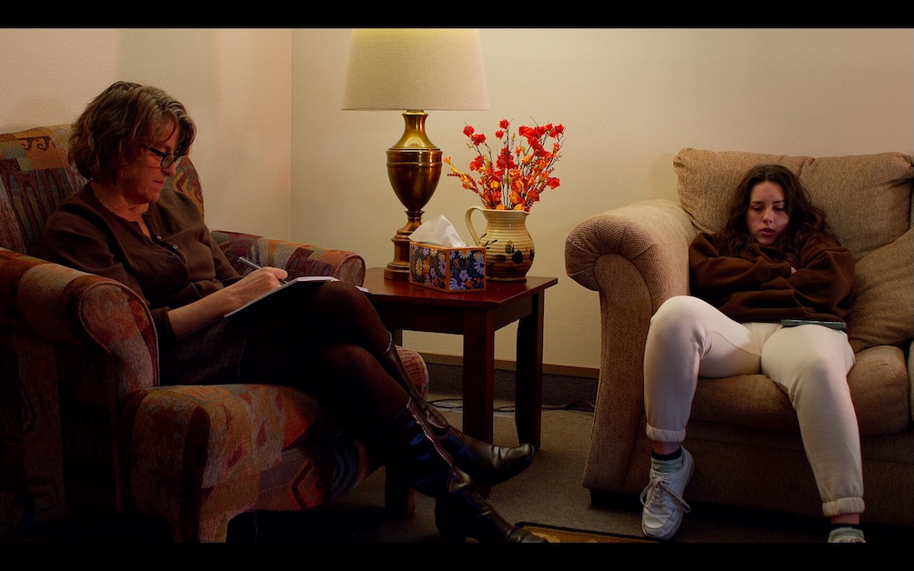 Image of two people sitting on chairs.