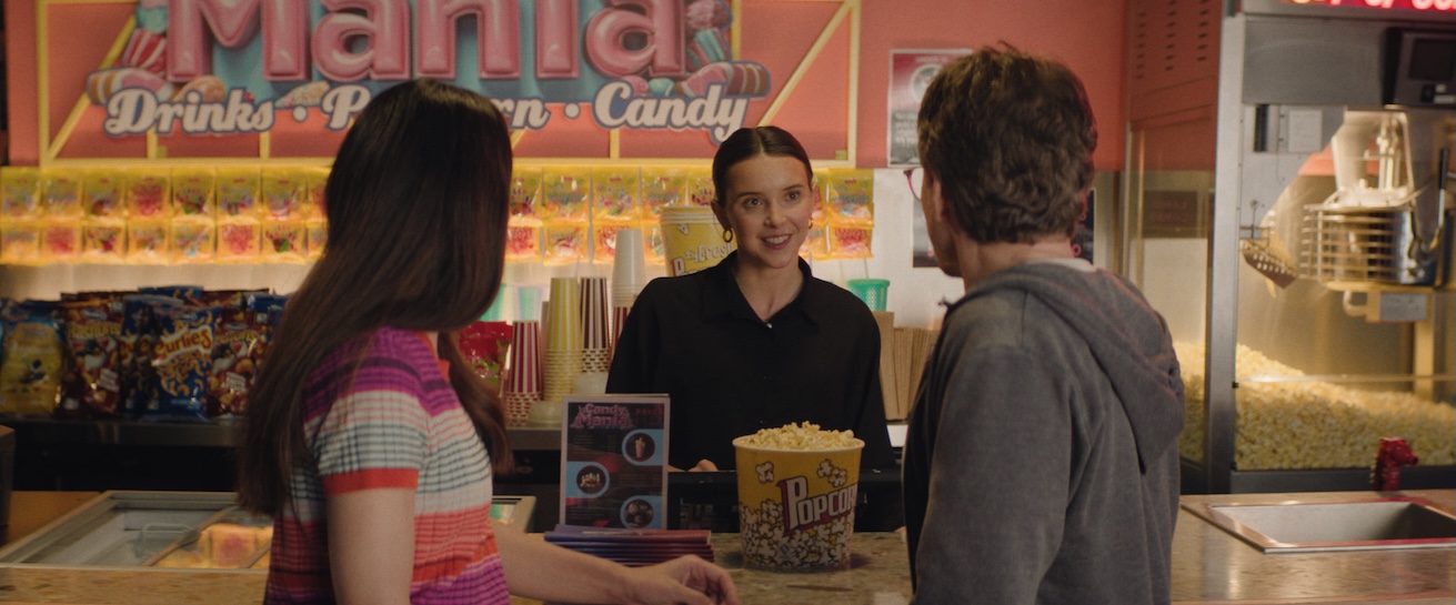 Image of two people at concessions stand with person behind counter.