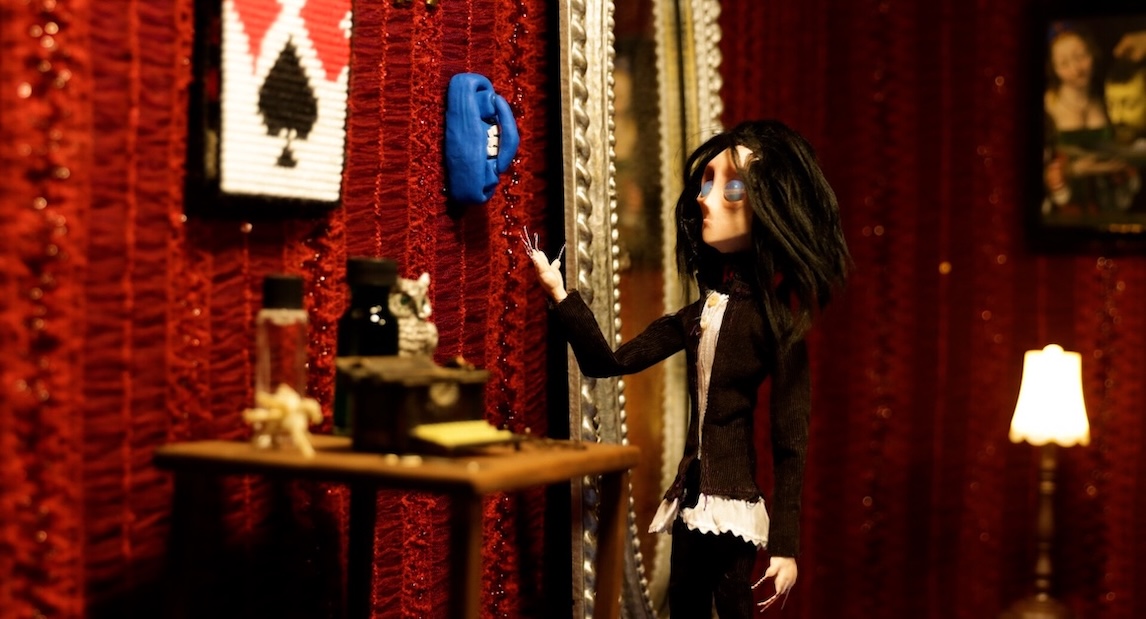 Marquis,_Repeat2 Image of stop motion animation of a person gesturing to a blue phone on the wall.