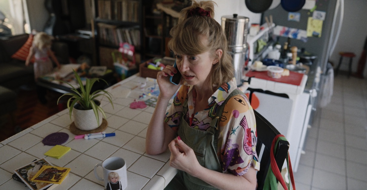 TP3 Image of person on the phone with a colorful shirt in a kitchen.