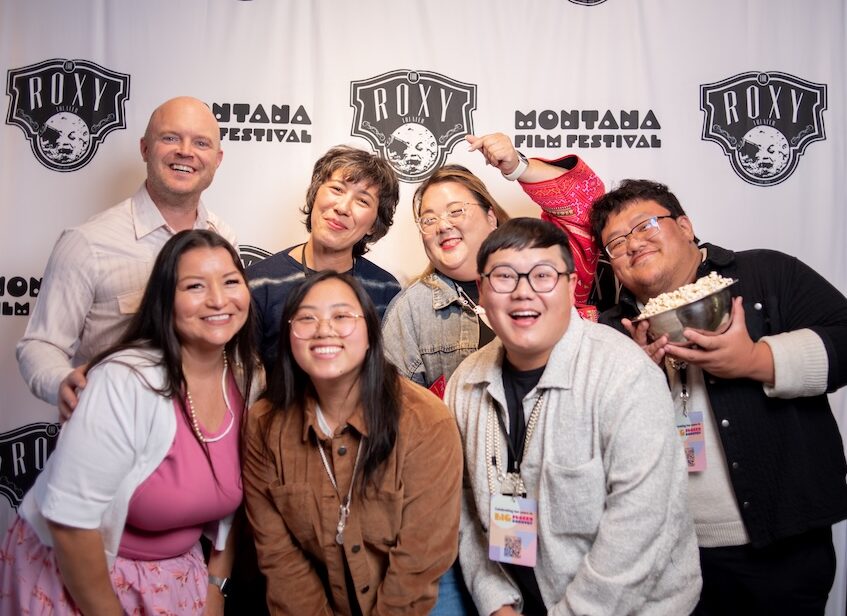 Image of people and smiling in front of stand and repeat.