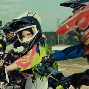 Image of motocross person looking at another.