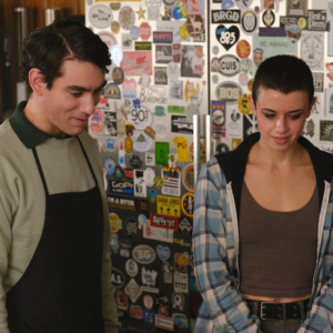 Image of two people looking down in front of appliance with stickers.