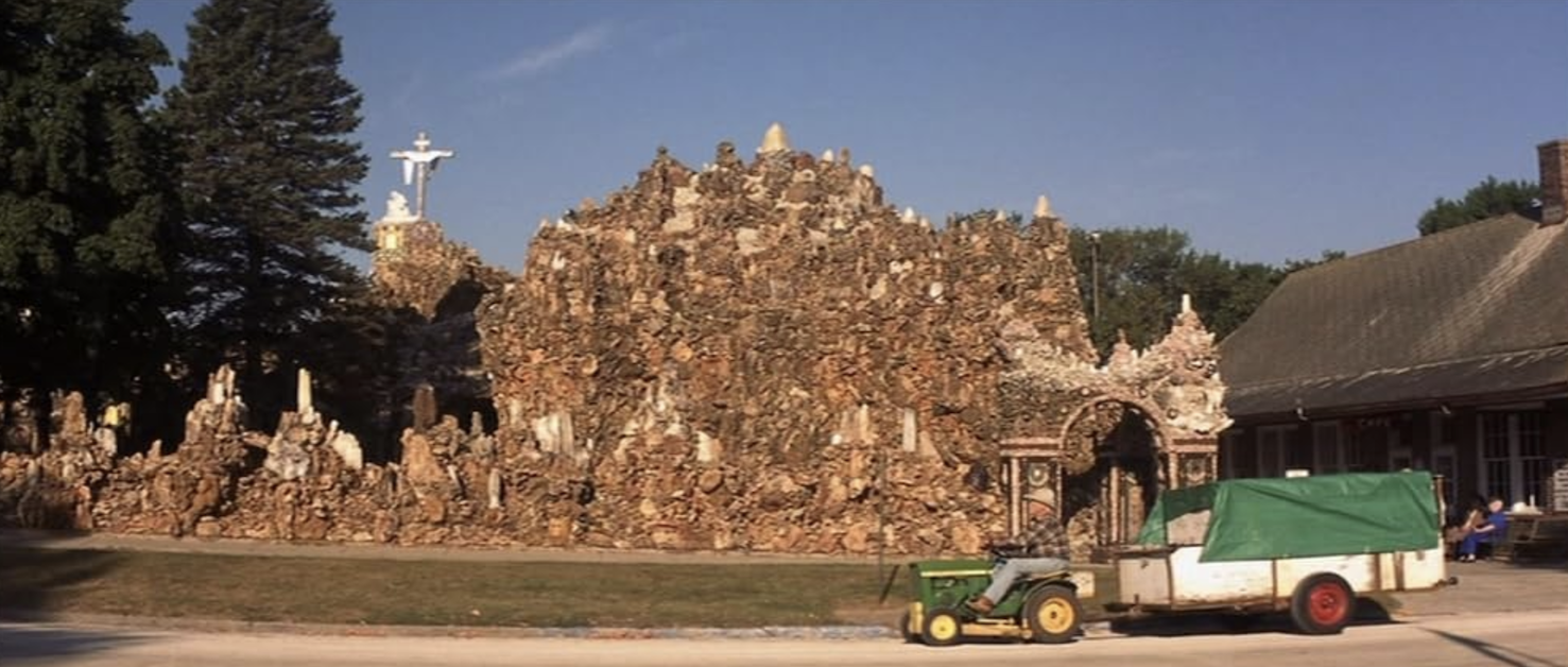 Image of person driving tractor past grotto.