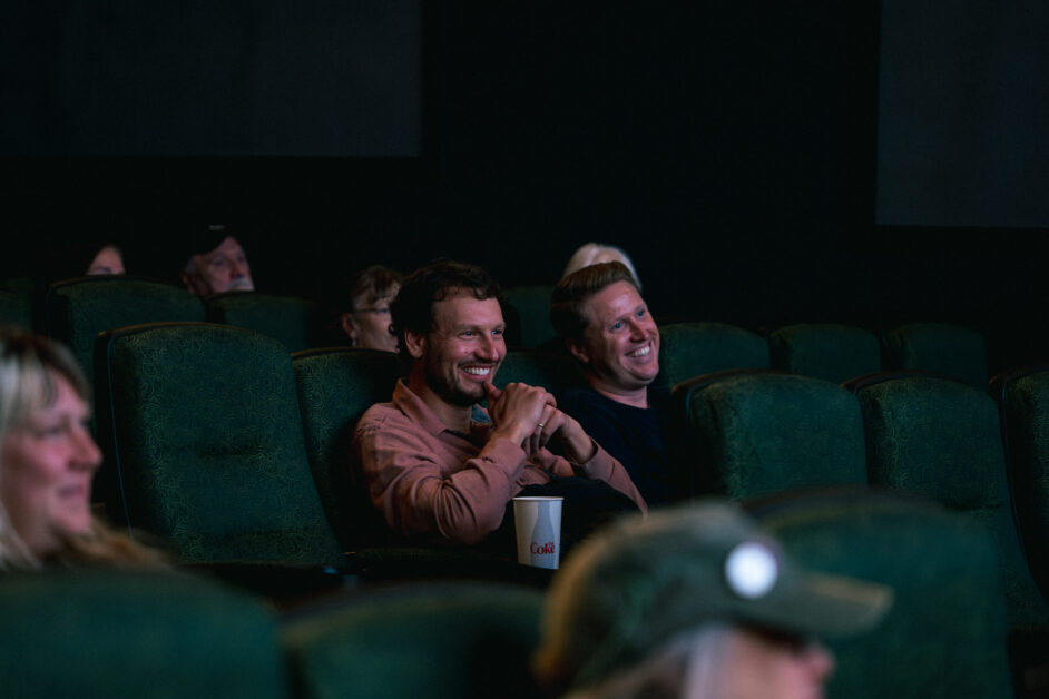 People sitting in theater smile.